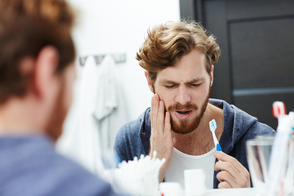 Man with sensitive teeth (What to Do About Sensitive Teeth)